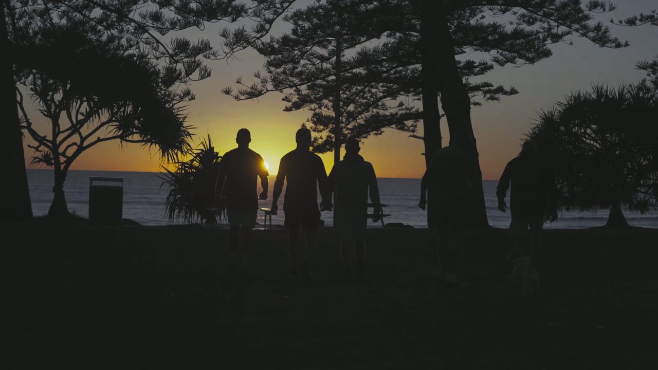 Brotherhood walking through Burleigh Heads at sunset